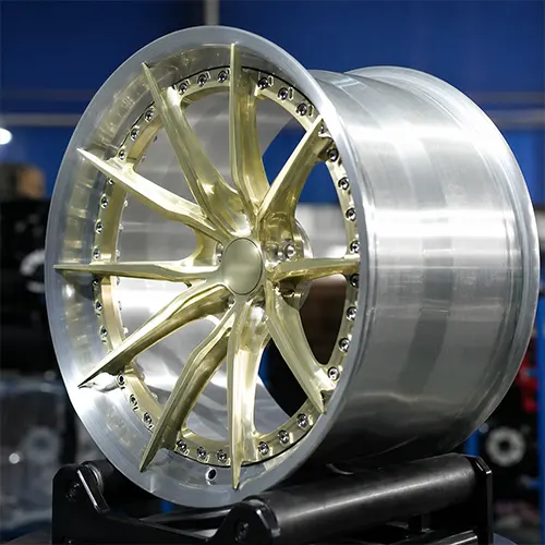 Angled workshop view of R35 champagne gold forged wheel with brushed silver lip