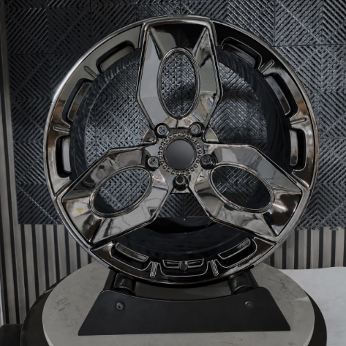 Close-up of electroplated black forged wheel with three-spoke machining details