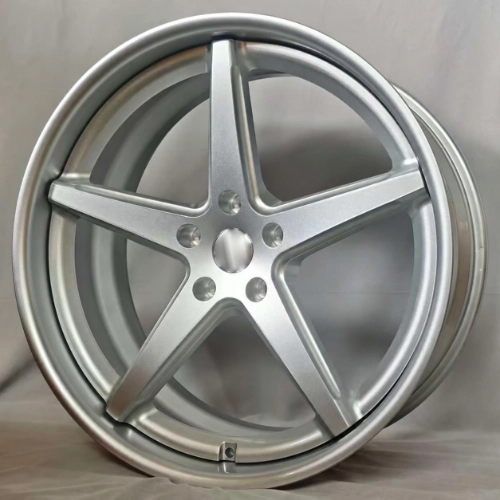 Close-up of gloss silver forged wheel with recessed center and sculpted five-spoke design