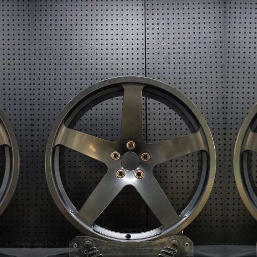 Front view of matte gunmetal forged wheel with broad spokes and open brake windows
